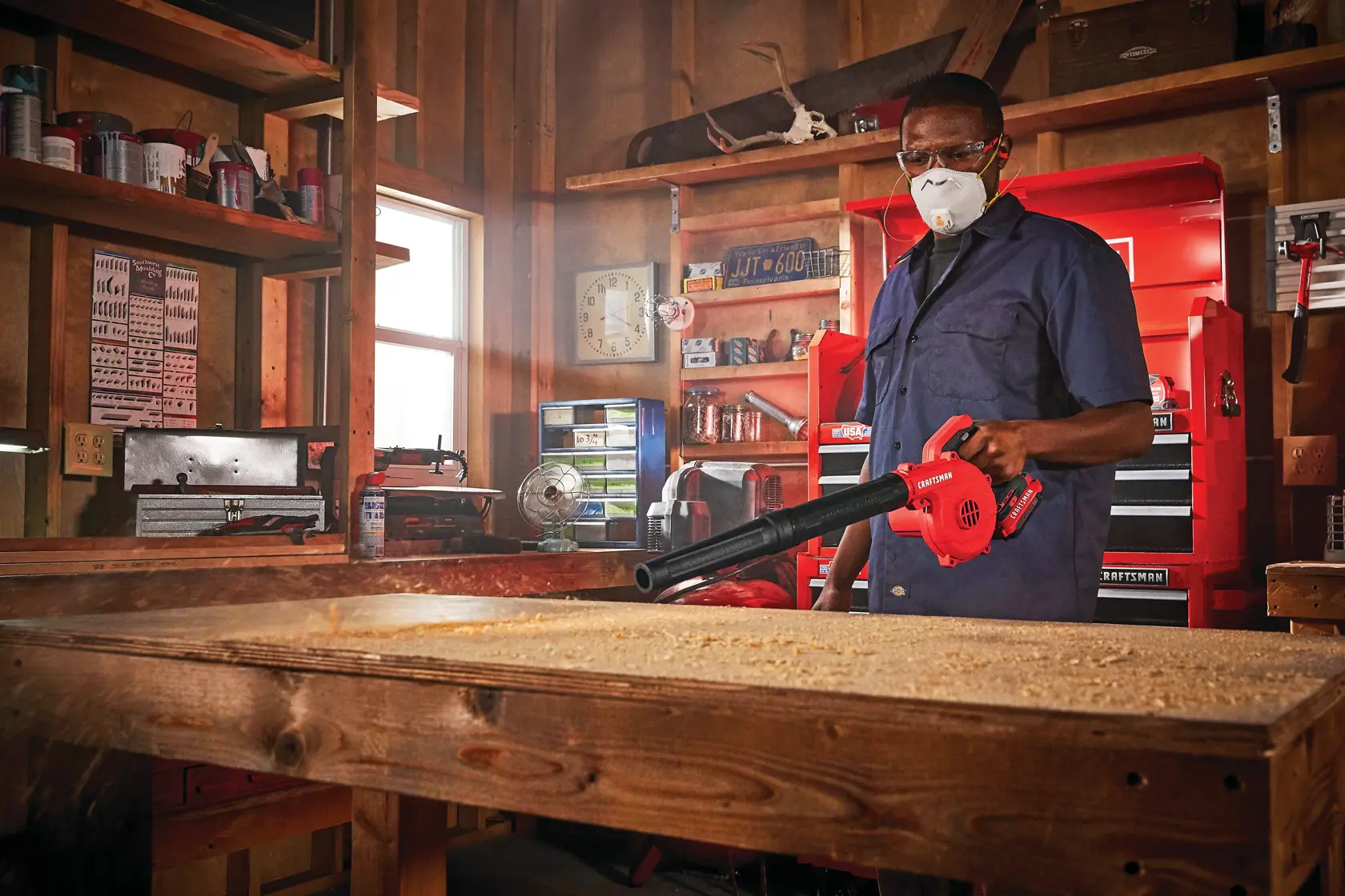 Cordless compact blower being used for blowing away wood dust