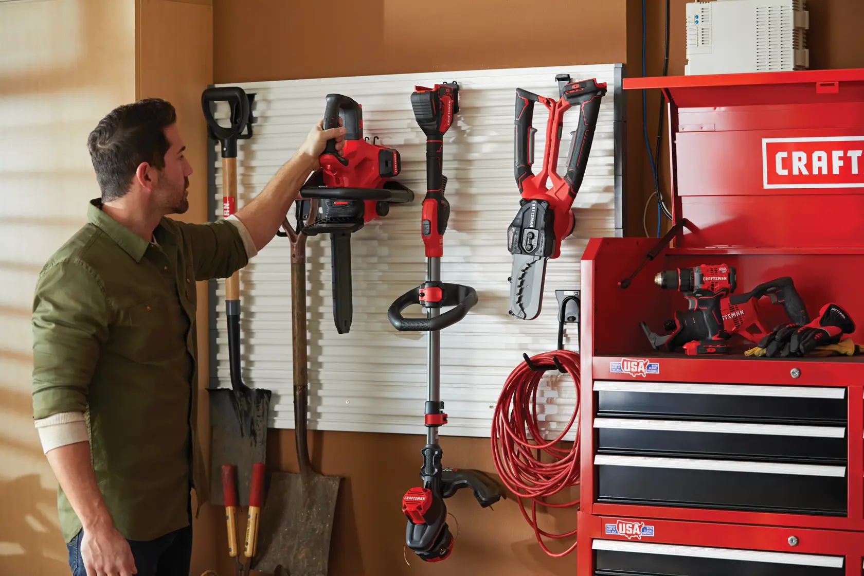 Man hanging the CRAFTSMAN Cordless 12-Inch Compact Chainsaw on a VERSATRACK wall system