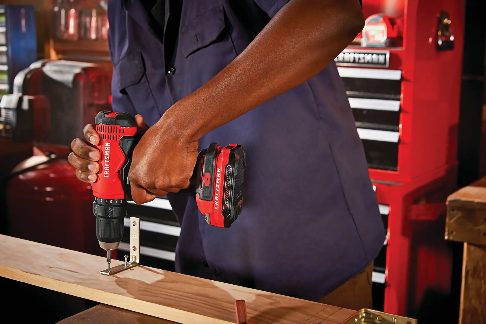 Half inch cordless drill and driver kit 2 batteries being used for fixing metal hook on wooden plank.