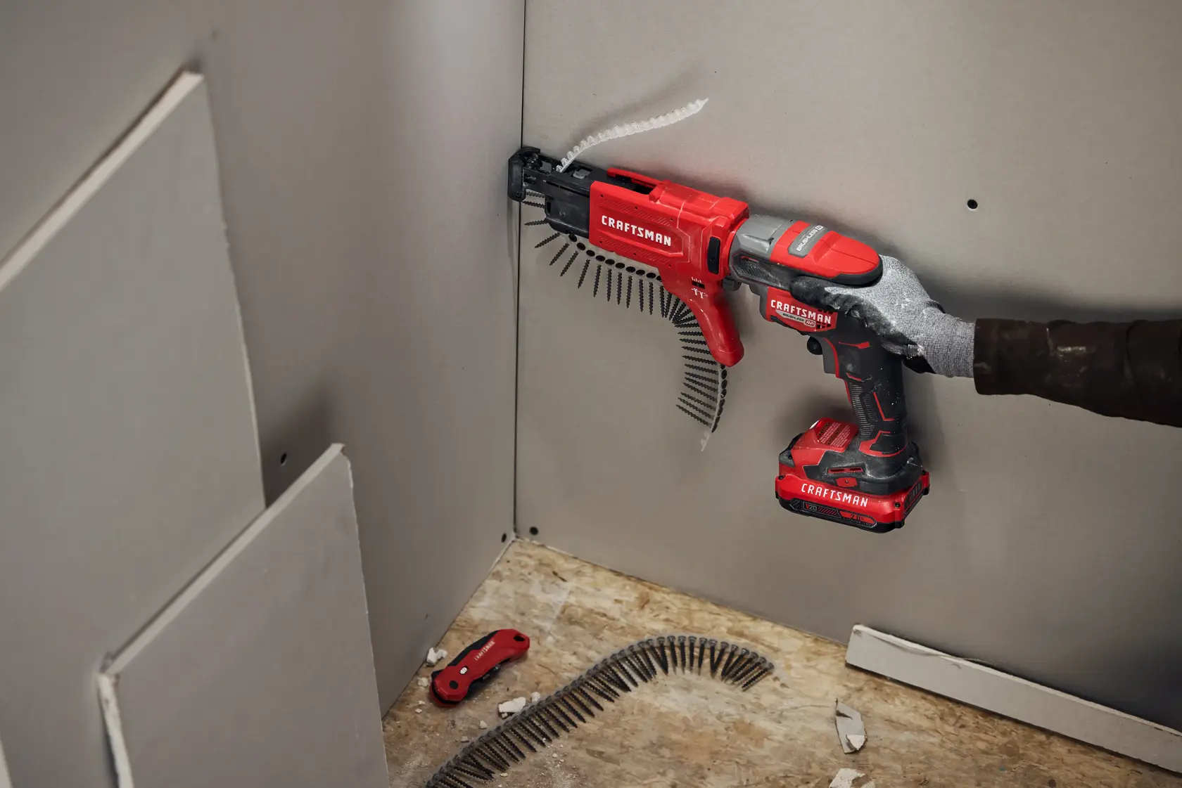 Photo of Craftsman cordless screw gun CMCF600B used for drywall installation, visible in a worksite with screws and panels.