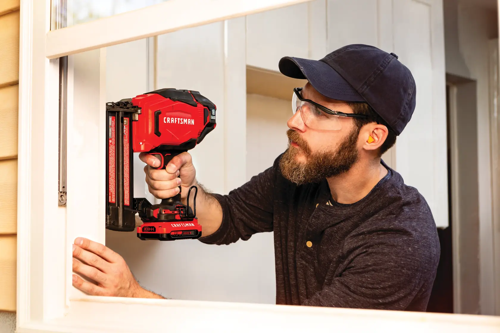 20 volt 18 gauge cordless brad nailer kit being used by a person to fix window panel.
