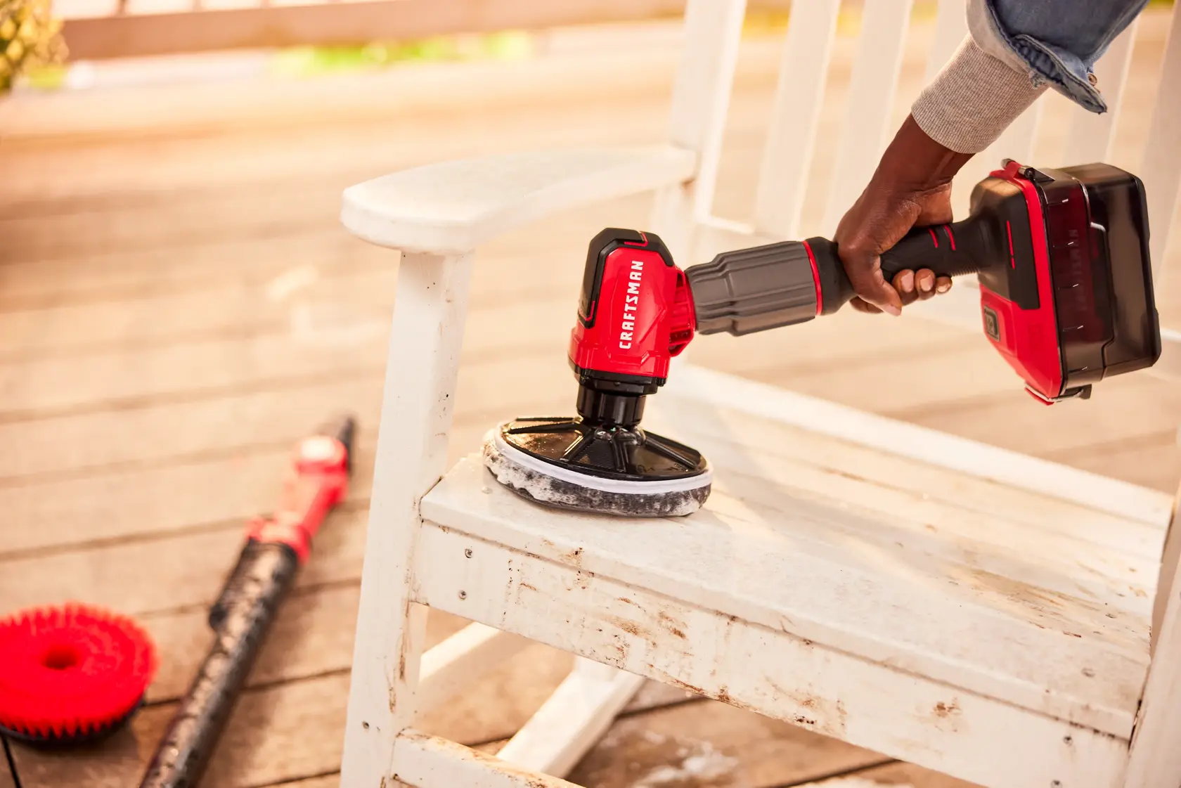 Zoom in view of female cleaning patio furniture with V20 Scrubber