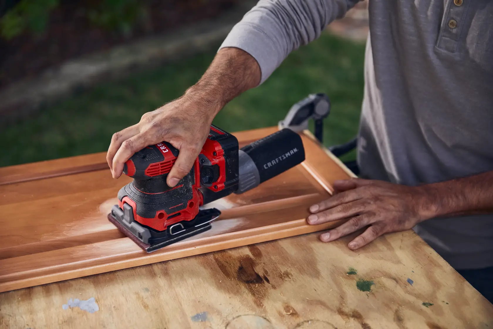 20 volt cordless quarter sheet sander in use.