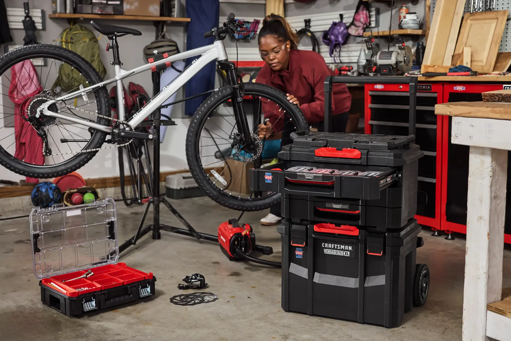 Photo of CRAFTSMAN storage stack CMST21445 in a garage with tools, open organizer, and bike repair setup.