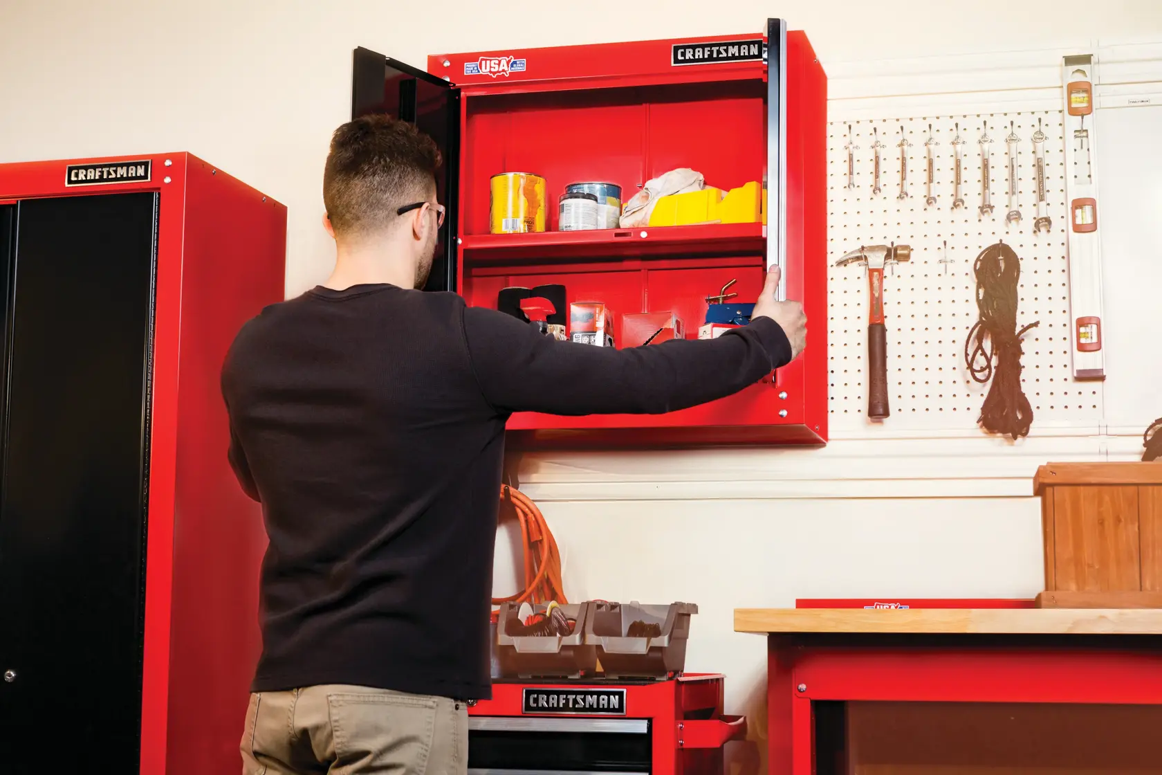 Photo of Craftsman wall cabinet SKU CMST22800RB open, displaying tools and storage in a workshop setting.