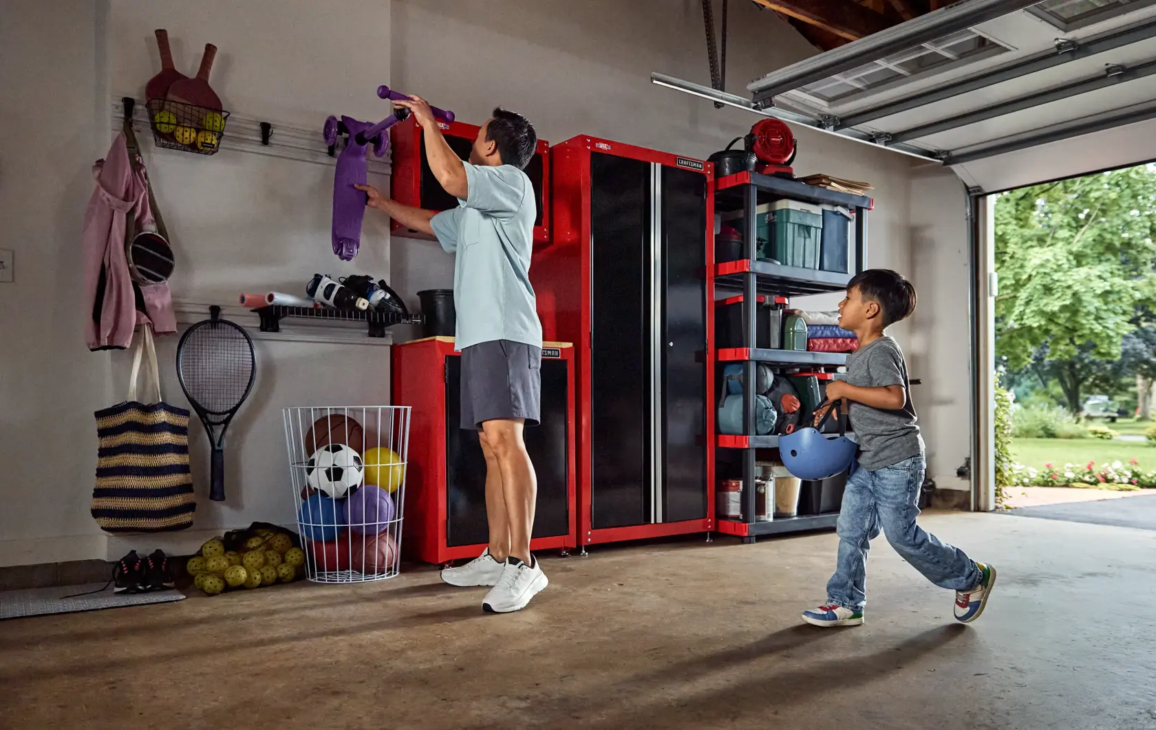 Photo of a garage with Craftsman storage cabinets and shelving, SKU CMST82617VT, organized with sports gear and bins.