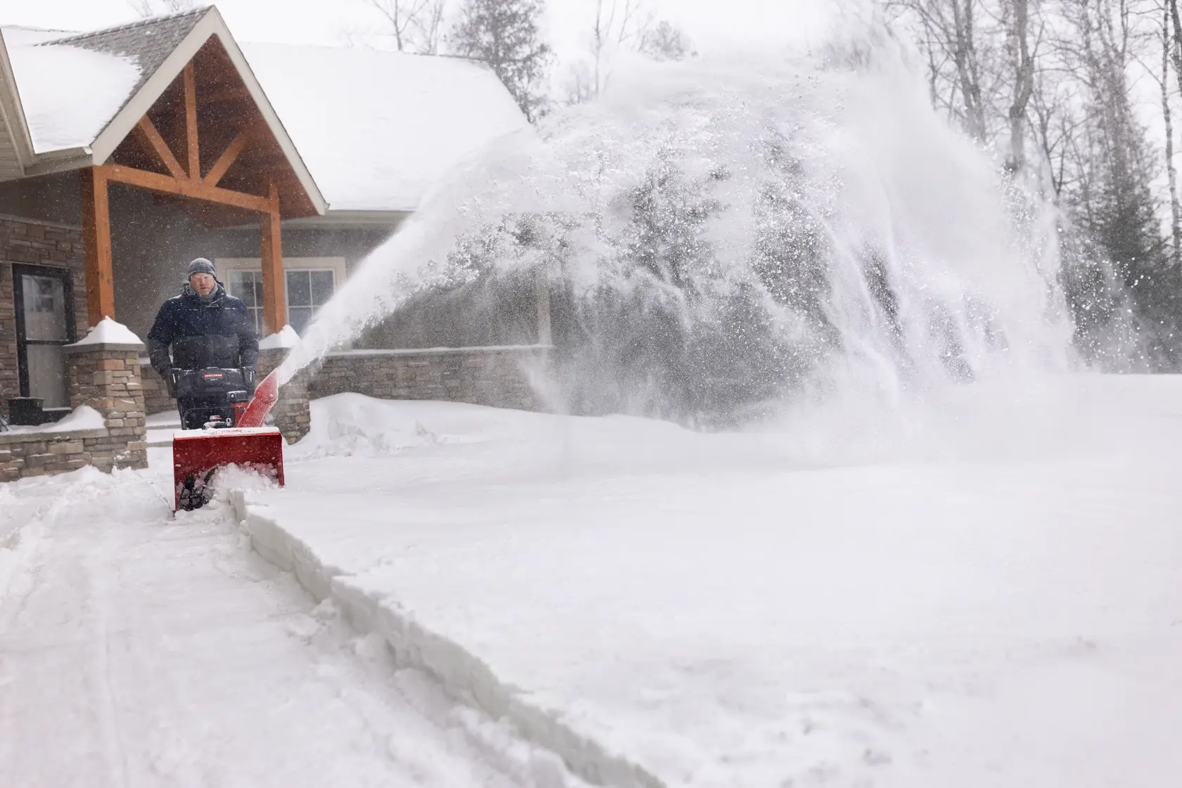 CRAFTSMAN Select 24 Snowblower clearing snow from sideway with house in background