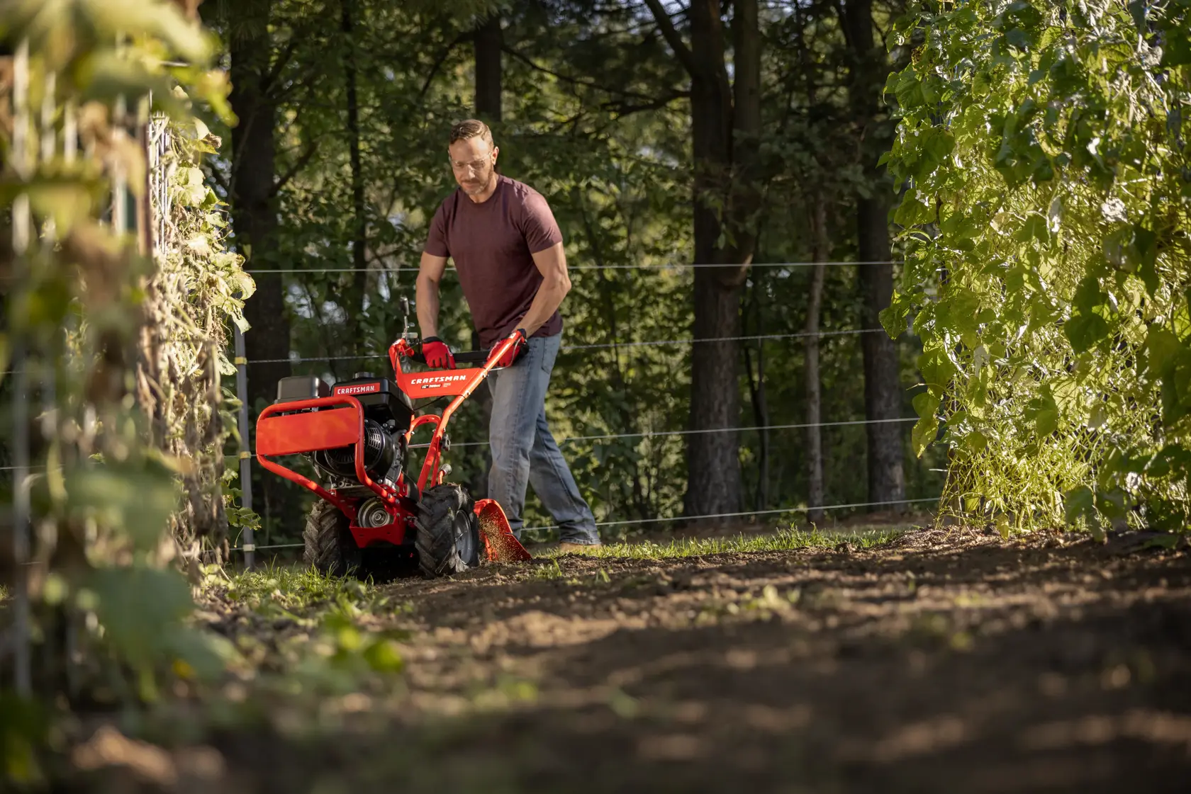 CRAFTSMAN 16-in. 208cc Gas Rear Tine Tiller tilling garden area with trees in background